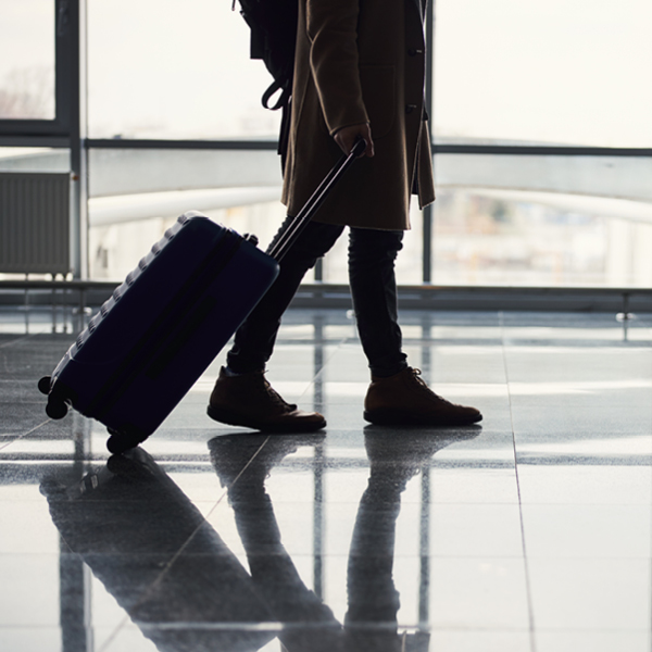 Viaggiatore in aereoporto con valigia