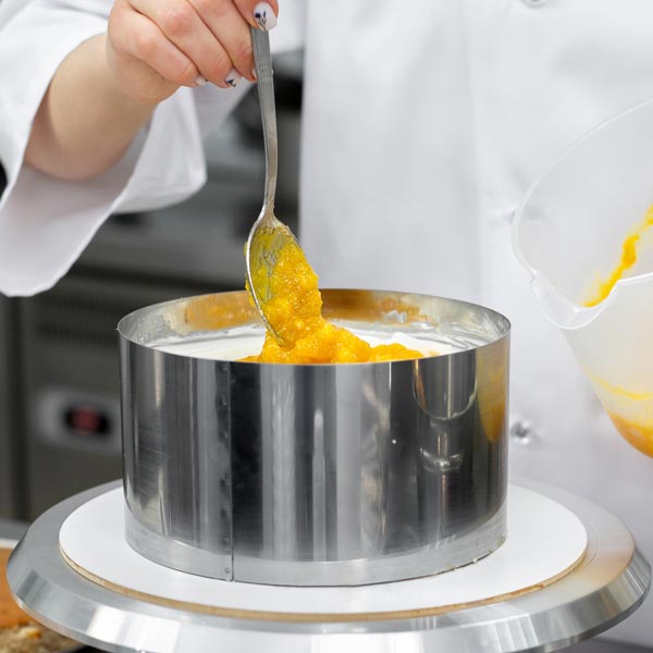 Un pasticcere farcisce di una torta
